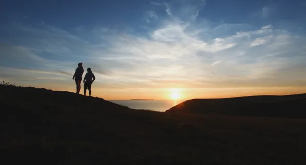 couple watching a sunset next to a rental motorhome