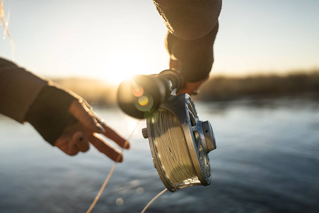 sunny closeup of a person's hands and the fishing rod