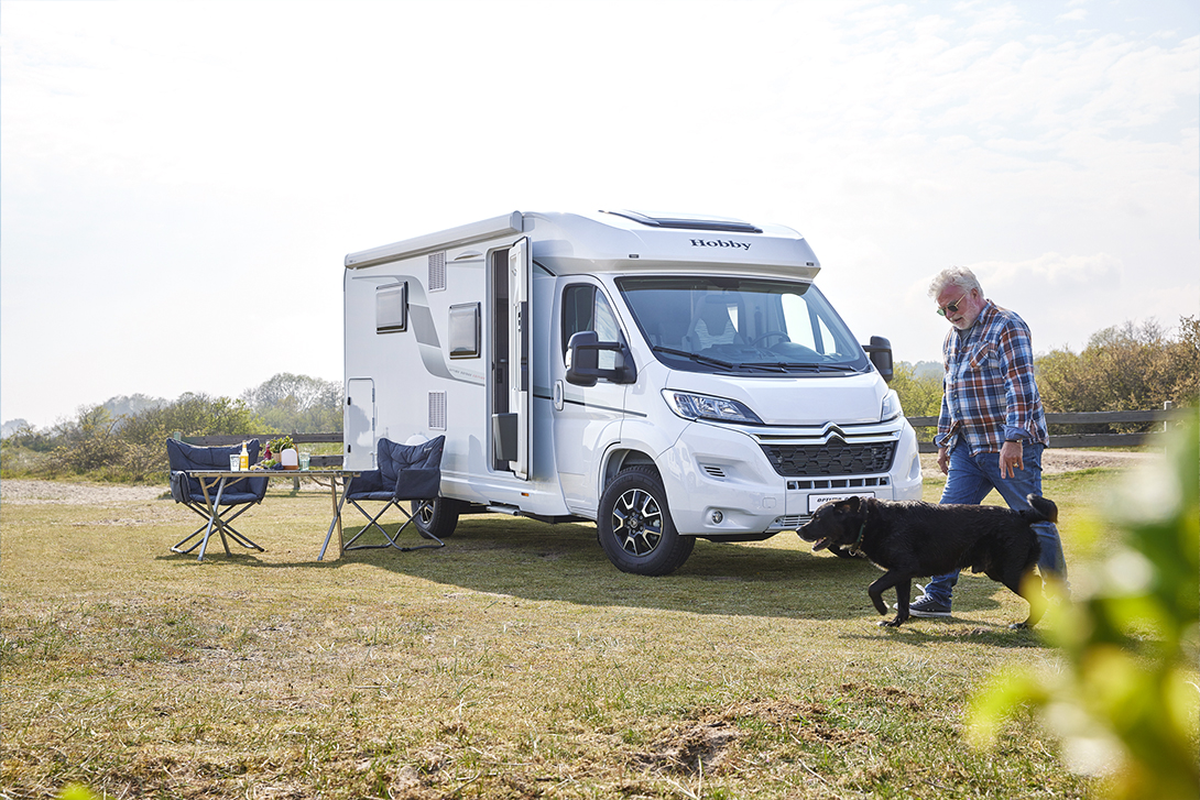 man and his dog camping with a motorhome